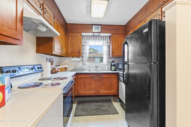 41D Cambridge Ct, Lakewood, NJ 08701 - kitchen with freestanding refrigerator, white electric range oven, under cabinet range hood, a sink, and light countertops
