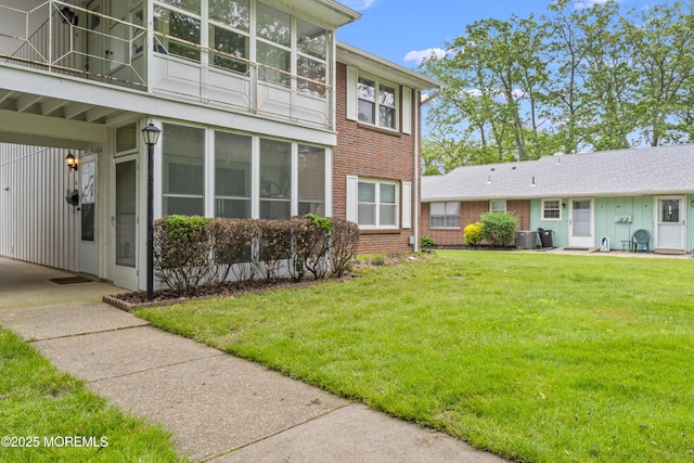 41D Cambridge Ct, Lakewood, NJ 08701 - view of side of property featuring brick siding, central AC, a lawn, and a sunroom