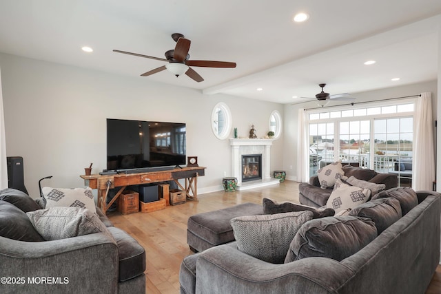 living area featuring a ceiling fan, recessed lighting, wood finished floors, a glass covered fireplace, and baseboards