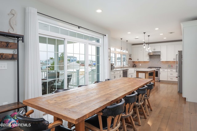 dining space with light wood-type flooring and recessed lighting