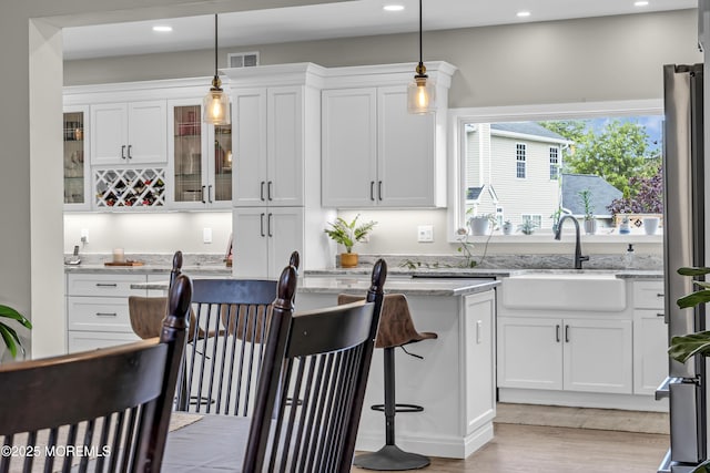 22 Ernest Dr, Lanoka Harbor, NJ 08734 - kitchen featuring a sink, white cabinets, glass insert cabinets, recessed lighting, and light stone counters