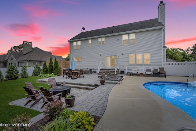 22 Ernest Dr, Lanoka Harbor, NJ 08734 - back of house at dusk with a patio area, an outdoor fire pit, a chimney, and outdoor dining space
