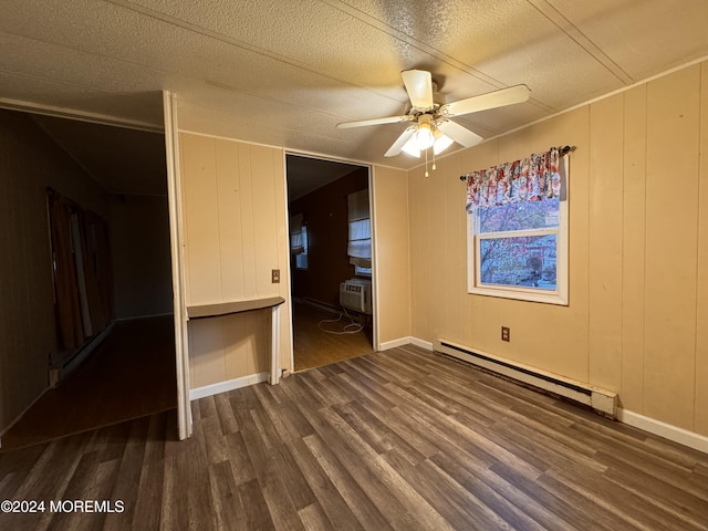 unfurnished bedroom with a baseboard heating unit, wood finished floors, a ceiling fan, and a textured ceiling