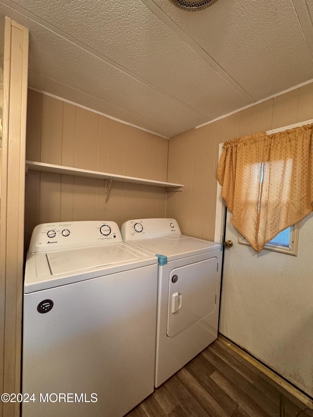 laundry area featuring dark wood-style flooring, washing machine and dryer, and a textured ceiling