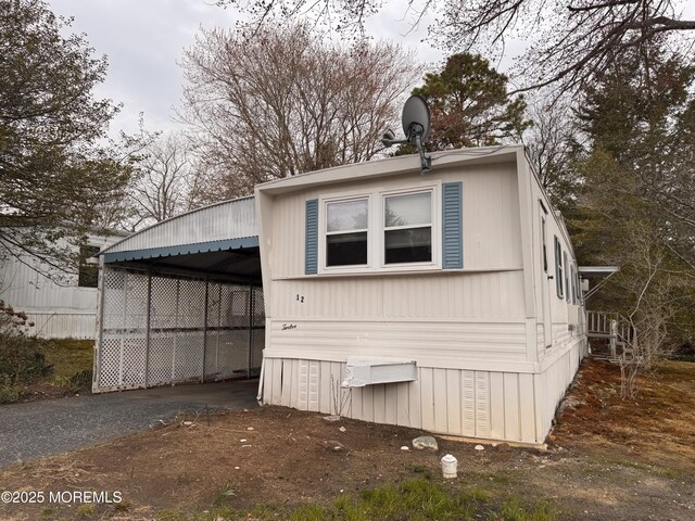 view of side of home with a carport and driveway