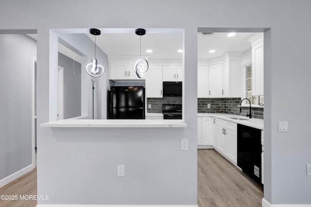 4B Greenwood Ln, Whiting, NJ 08759 - kitchen with black appliances, light wood finished floors, a sink, white cabinetry, and backsplash