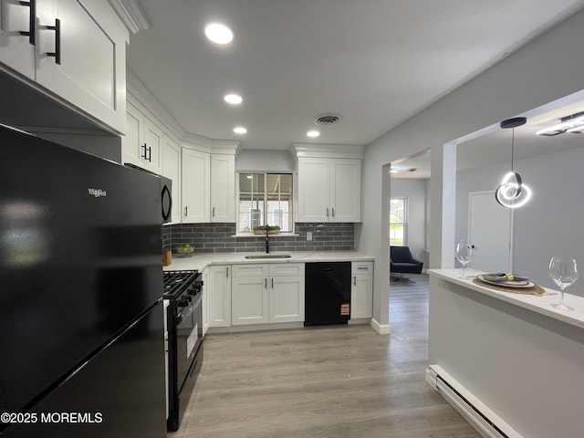 4B Greenwood Ln, Whiting, NJ 08759 - kitchen featuring black appliances, a sink, light countertops, baseboard heating, and tasteful backsplash