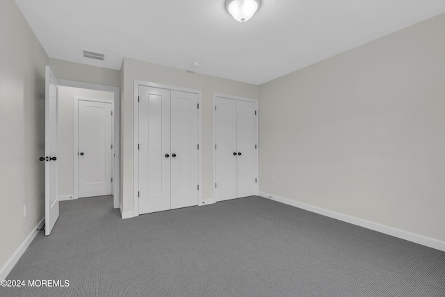 24 Golders Green Rd, Lakewood, NJ 08701 - unfurnished bedroom featuring dark carpet, baseboards, and multiple closets