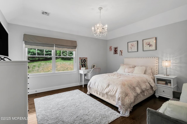 bedroom with a chandelier, wood finished floors, and baseboards