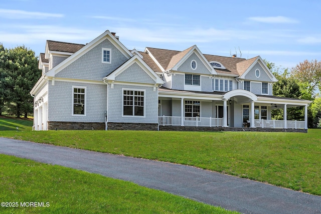shingle-style home with a porch, a front yard, and a ceiling fan