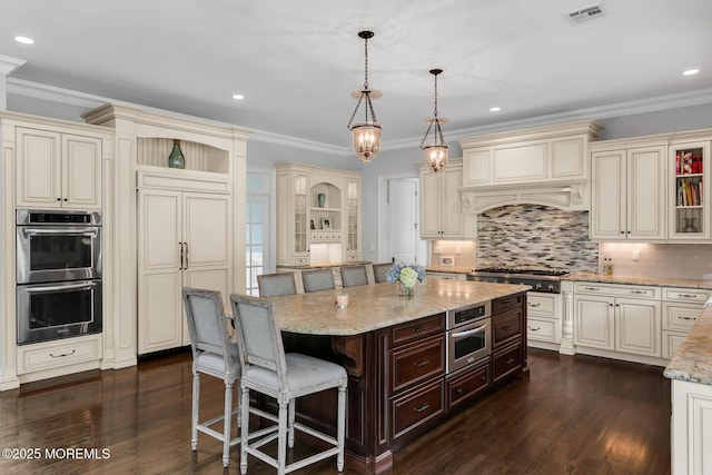 kitchen with open shelves, cream cabinetry, ornamental molding, and recessed lighting