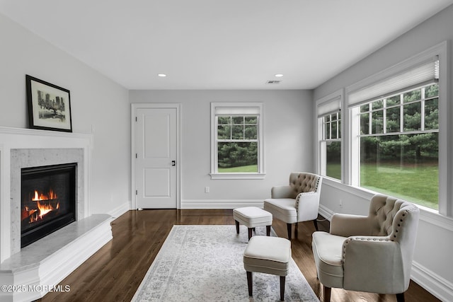 living area with a premium fireplace, dark wood-type flooring, recessed lighting, and baseboards