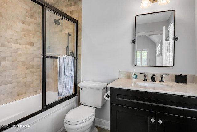 full bath featuring toilet, bath / shower combo with glass door, vanity, and baseboards