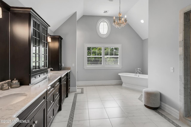 bathroom featuring vaulted ceiling, inlaid floor details, a soaking tub, a chandelier, and double vanity