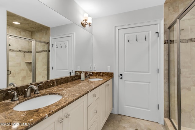 full bath featuring a stall shower, double vanity, and tile patterned floors