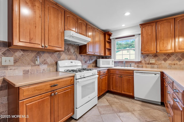 11 S Point Ct, Toms River, NJ 08757 - kitchen with white appliances, under cabinet range hood, a sink, brown cabinetry, and light countertops