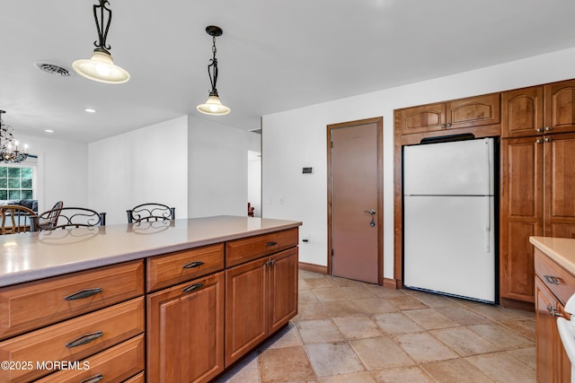 11 S Point Ct, Toms River, NJ 08757 - kitchen with freestanding refrigerator, light countertops, decorative light fixtures, brown cabinets, and a chandelier