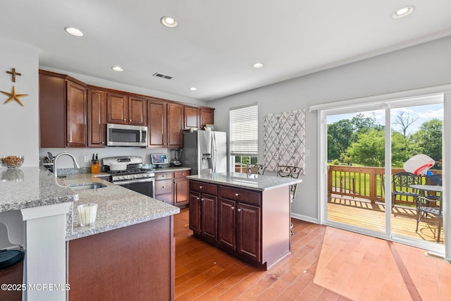 111 Warbler Way Unit 1000, Freehold, NJ 07728 - kitchen featuring appliances with stainless steel finishes, a sink, light stone countertops, recessed lighting, and light wood-type flooring