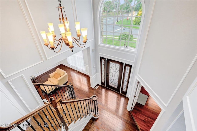 entrance foyer featuring a chandelier, wood finished floors, and stairway