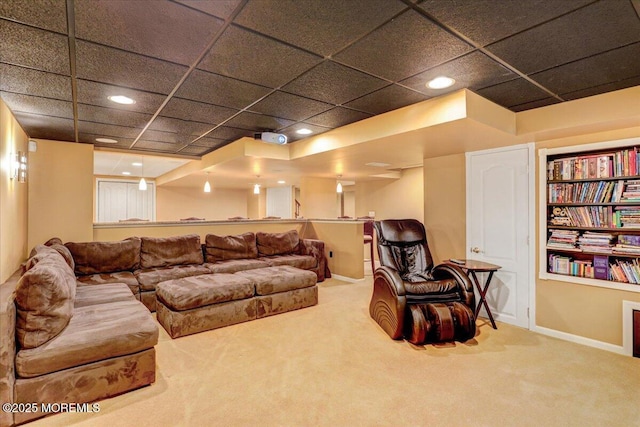 carpeted living room featuring recessed lighting, baseboards, and a drop ceiling