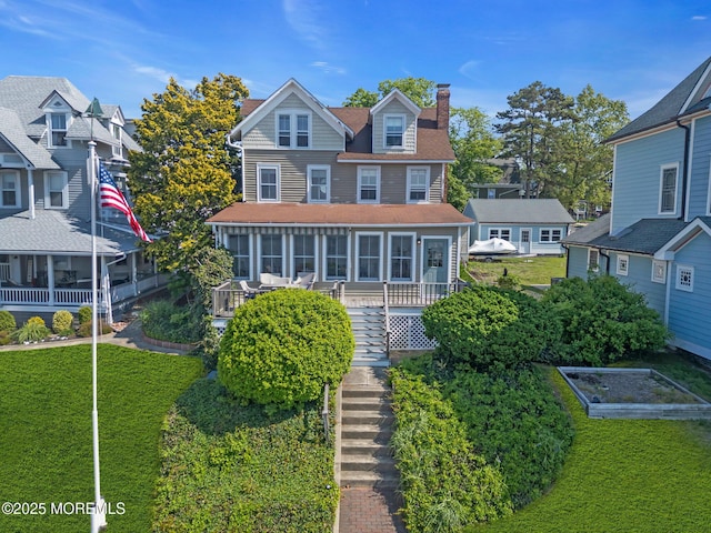 58 River Ave, Island Heights, NJ 08732 - view of front facade with a sunroom, a garden, a chimney, stairs, and a front yard