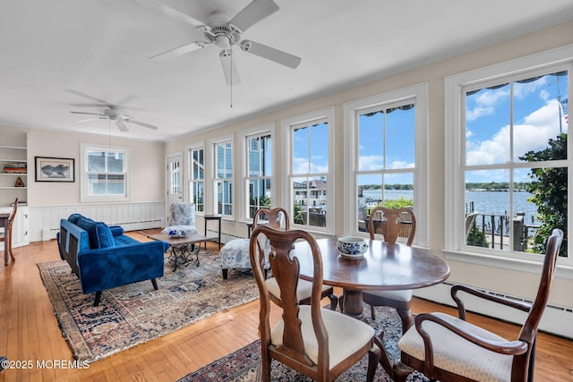 58 River Ave, Island Heights, NJ 08732 - dining area featuring a ceiling fan, a water view, light wood finished floors, crown molding, and a wainscoted wall