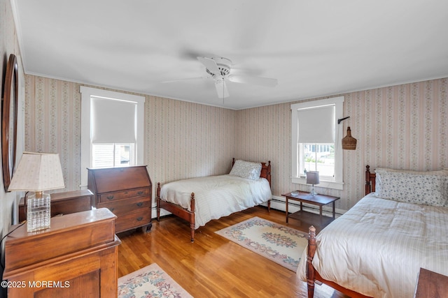 58 River Ave, Island Heights, NJ 08732 - bedroom with wood finished floors, ornamental molding, wallpapered walls, a baseboard radiator, and a ceiling fan