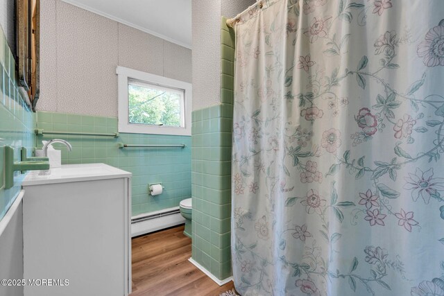 58 River Ave, Island Heights, NJ 08732 - full bathroom with a baseboard heating unit, tile walls, wood finished floors, toilet, and vanity