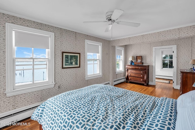 58 River Ave, Island Heights, NJ 08732 - bedroom with baseboard heating, wood finished floors, multiple windows, crown molding, and wallpapered walls