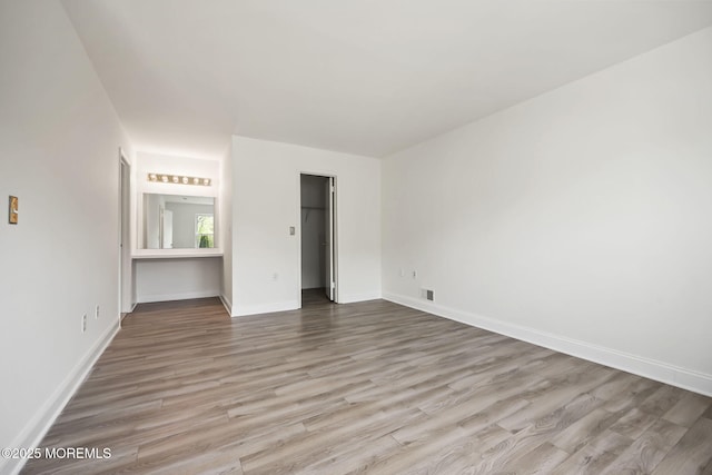 unfurnished bedroom with wood finished floors and baseboards