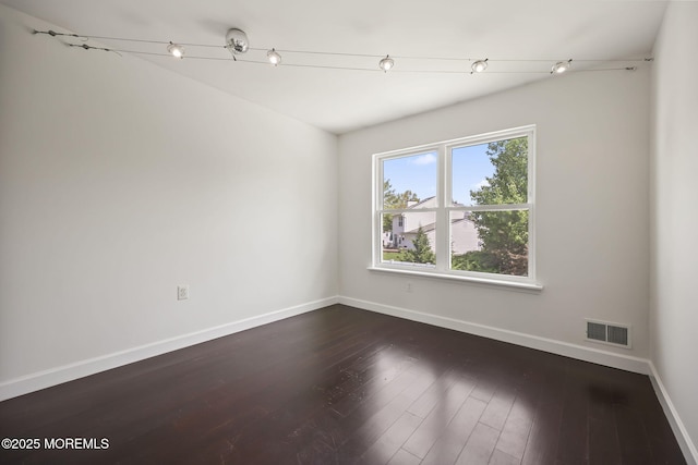 empty room with baseboards and dark wood-style flooring