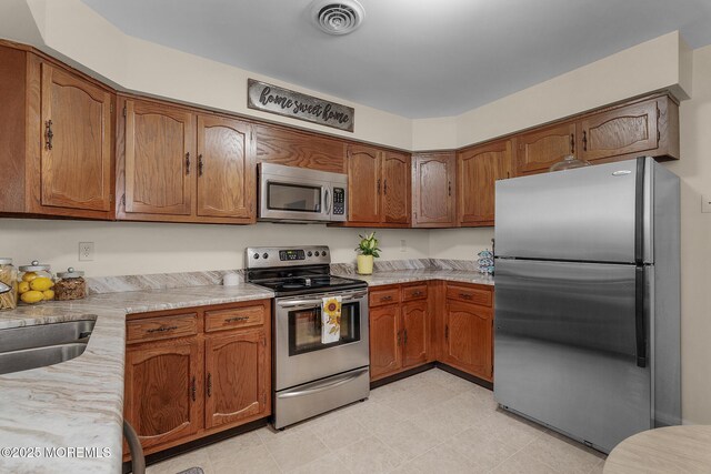 2A Jackson Ct, Whiting, NJ 08759 - kitchen featuring appliances with stainless steel finishes, light countertops, and brown cabinets