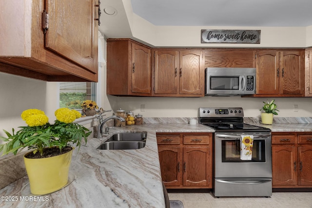 2A Jackson Ct, Whiting, NJ 08759 - kitchen featuring stainless steel appliances, a sink, brown cabinets, light tile patterned floors, and light stone counters