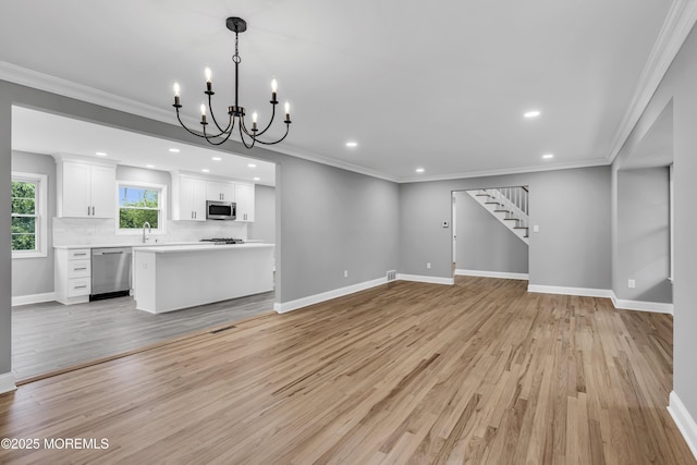 92 Sargent Rd, Freehold, NJ 07728 - unfurnished living room with a chandelier, stairway, light wood-style floors, recessed lighting, and baseboards