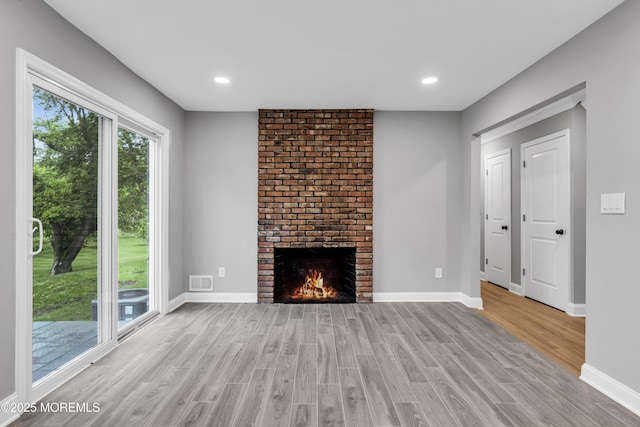 92 Sargent Rd, Freehold, NJ 07728 - unfurnished living room featuring light wood-type flooring, a brick fireplace, baseboards, and recessed lighting