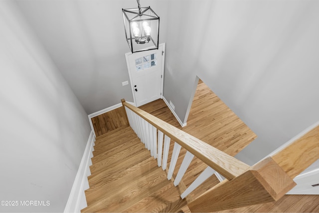 92 Sargent Rd, Freehold, NJ 07728 - stairs featuring a chandelier, wood finished floors, and baseboards