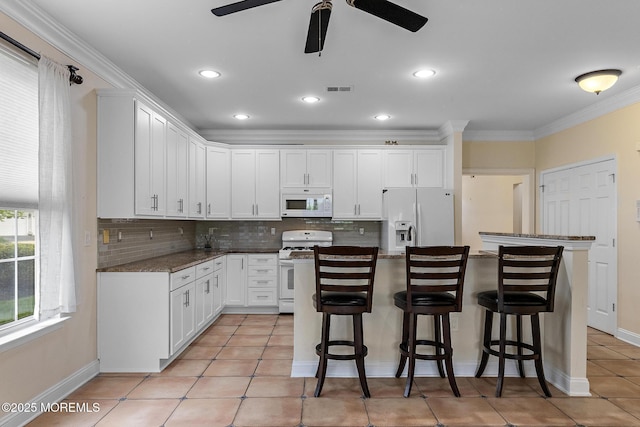 7 Spring Lake Ct, Barnegat, NJ 08005 - kitchen with white appliances, ceiling fan, backsplash, a kitchen bar, and white cabinets