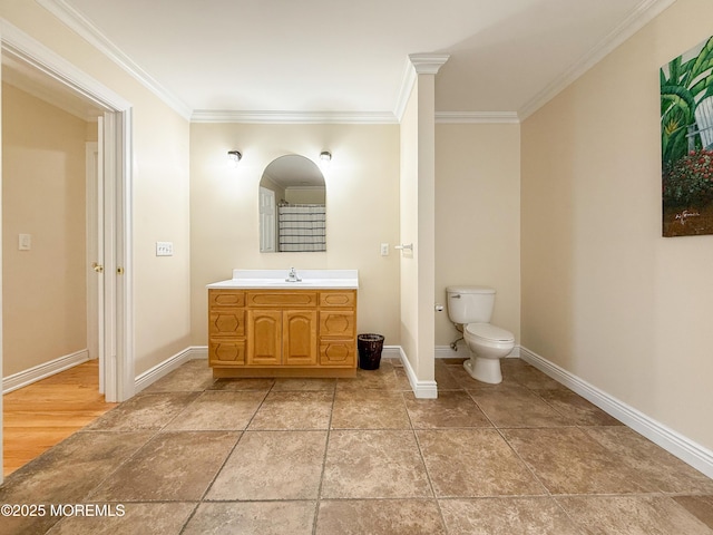 bathroom featuring ornamental molding, toilet, baseboards, and vanity