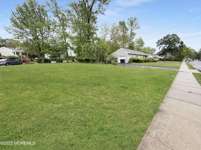 view of green lawn featuring a garage