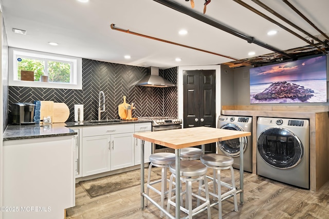 laundry area featuring washing machine and dryer, wet bar, recessed lighting, and light wood-style flooring