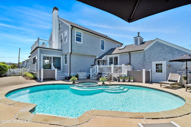 view of pool featuring a patio, fence, a pool with connected hot tub, and a deck