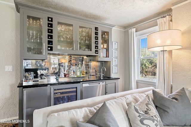 indoor wet bar with a textured wall, a textured ceiling, beverage cooler, backsplash, and appliances with stainless steel finishes
