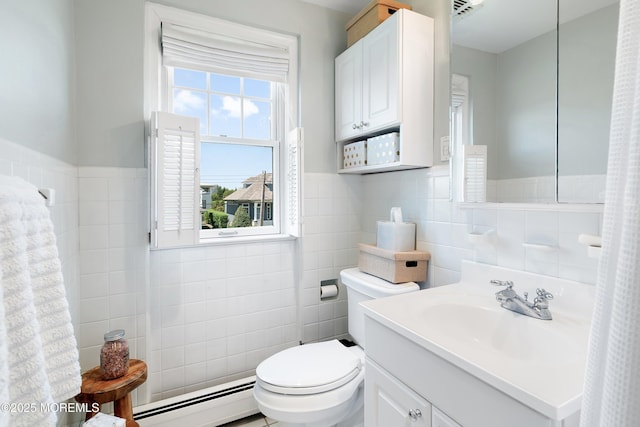 bathroom featuring tile walls, a baseboard radiator, toilet, vanity, and wainscoting