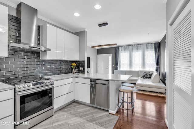 7 Samantha Dr, Tinton Falls, NJ 07712 - kitchen featuring appliances with stainless steel finishes, crown molding, wall chimney exhaust hood, modern cabinets, and light countertops