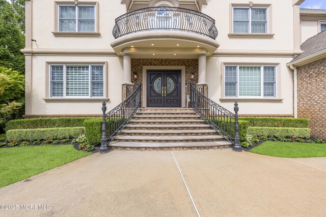 821 Woodland Dr, Lakewood, NJ 08701 - view of exterior entry featuring stucco siding and a balcony