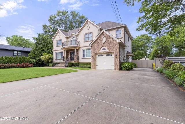 821 Woodland Dr, Lakewood, NJ 08701 - view of front of property featuring a balcony, brick siding, stucco siding, concrete driveway, and a gate