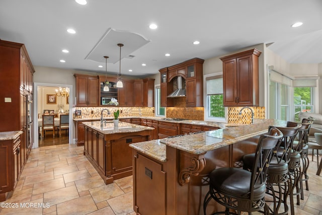 821 Woodland Dr, Lakewood, NJ 08701 - kitchen featuring a sink, a peninsula, a kitchen island with sink, light stone countertops, and recessed lighting