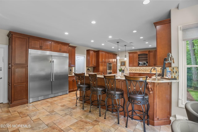 821 Woodland Dr, Lakewood, NJ 08701 - kitchen featuring appliances with stainless steel finishes, open shelves, backsplash, a kitchen breakfast bar, and light stone countertops