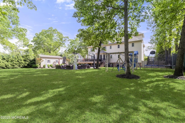 821 Woodland Dr, Lakewood, NJ 08701 - view of green lawn featuring a trampoline, a playground, and a wooden deck