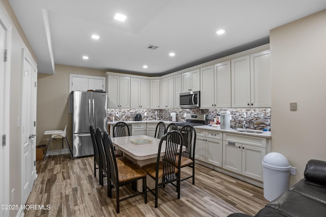 821 Woodland Dr, Lakewood, NJ 08701 - kitchen with appliances with stainless steel finishes, tasteful backsplash, light wood-style flooring, and recessed lighting